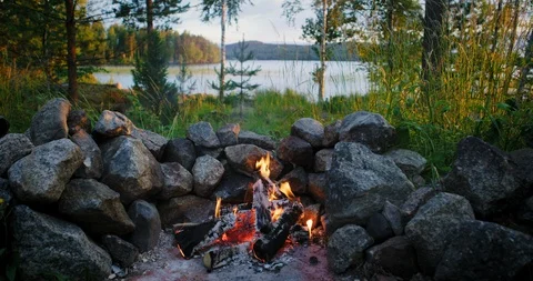 Beautiful view of campfire and sunset over the lake on background. Stock Footage 112112686