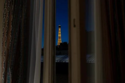 A beautiful view of the Eiffel tower at nighttime captured from the window of 스톡 사진
