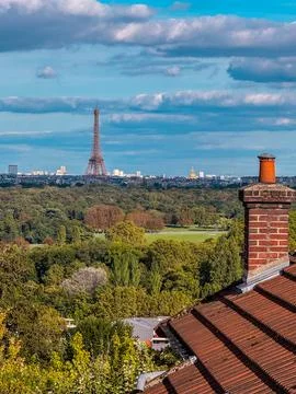 A beautiful view of the Eiffel Tower rises above trees and greenery, captured Stock Photos