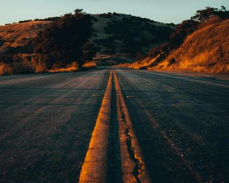 Beautiful view of an empty road with hills during sunrise Foto stock