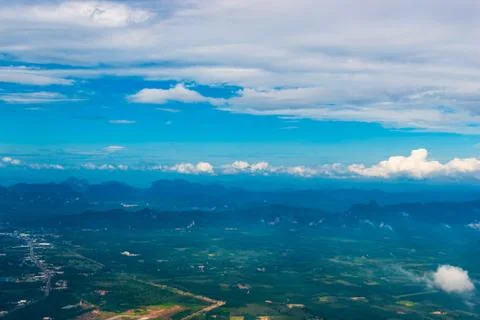 Beautiful view of the fields, clouds and mountains from the airplane Stock Photos