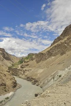 Beautiful view of flowing river in between  rocky mountains with clouds  Stock Photos