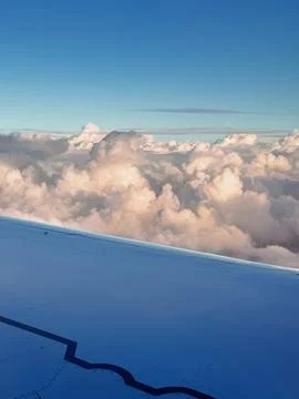 Beautiful view of fluffy clouds shot from airplane window at daylight Stock Photos