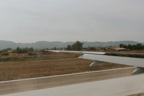 Beautiful view of the light gray left wing of an airplane with open flaps on  Stock Photos