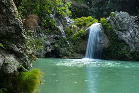Beautiful view of low waterfall falling into a pool with turquoise water Foto stock