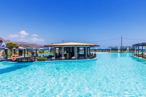 Beautiful view of luxury infinity pool with swim-up bar beside Cretan Sea Stock Photos