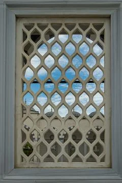 Beautiful view of mosque domes seen through a geometric lattice window agai.. Stock-Fotos