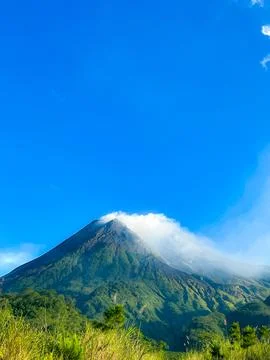 Beautiful view of mount merapi against blue sky and white cloud Stock Photos