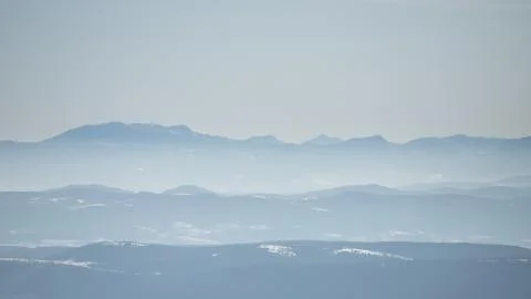 Beautiful view of the mountain range partially covered by fog and snow with c Stock Photos