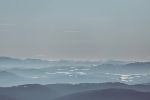 Beautiful view of the mountain range partially covered by fog and snow with c Stock Photos