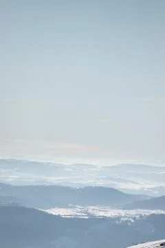 Beautiful view of the mountain range partially covered by fog and snow with c Stock Photos