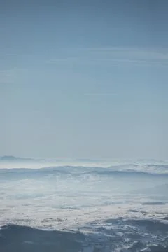 Beautiful view of the mountain range partially covered by fog and snow with c Stock Photos
