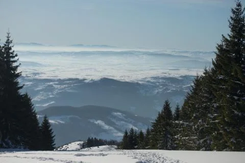 Beautiful view of the mountain range partially covered by fog and snow with c Stock Photos