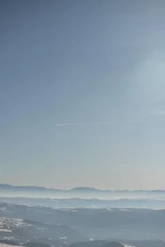 Beautiful view of the mountain range partially covered by fog and snow with c Stock Photos