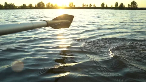 Beautiful view of oar paddle on calm water against the background of sunset rays Stock Footage 158834576