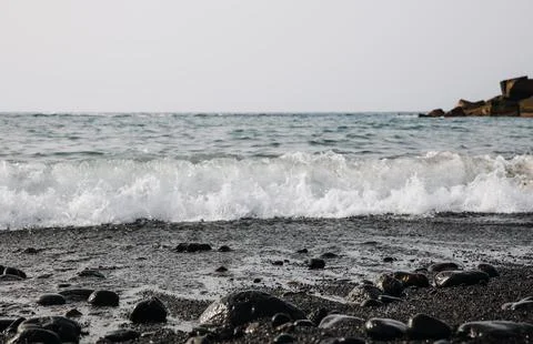 Beautiful view of the ocean wave on the black volcanic beach. Stock Photos