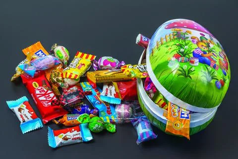 Beautiful  view of an open Easter egg with sweets isolation on black background. Stock Photos