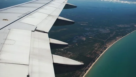 Beautiful view over the wing of a flying plane over tropical Islands. Prepare Stock Footage 88285579