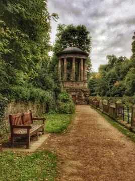 Beautiful view of a park with an old building under the cloudy sky Fotos de archivo