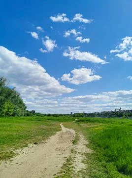 Beautiful view of the path in the park, green grass, blue sky Stock Photos