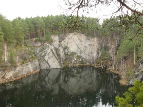 Beautiful view of a pit in an environment of rocks and trees. Stock Photos