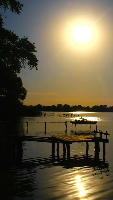 Beautiful view of the river at sunset. Black silhouettes of trees, boats, a.. Stock Footage 285707903