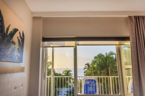 Beautiful view from the room through the open balcony door to the palm trees. Stock Photos