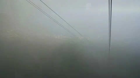 Beautiful view from ropeway car moving up the mountain in Cloudy day Stock Footage 109528571