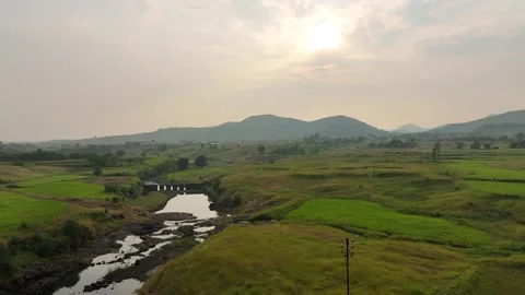 Beautiful view of a serene river surrounded by lush green fields, distant h.. Stock Footage 305835813