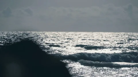 Beautiful view of silhouette waves crashing in slomo with rocks on foreground v3 Stock Footage 119533656