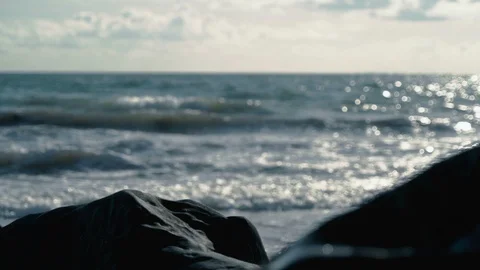 Beautiful view of slow motion waves behind smooth rocks on beach Stock Footage 119533119