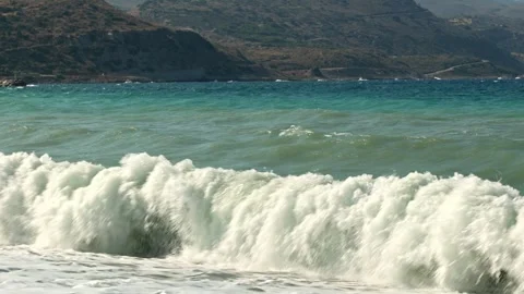 Beautiful view of storm waves rolling across sea against mountainous coastline. Stock Footage 341613534