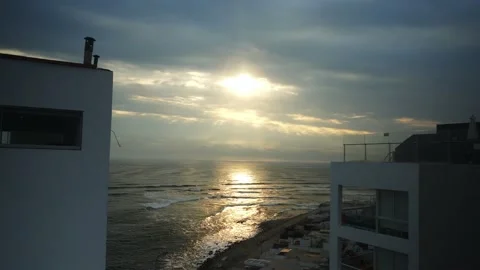 Beautiful view of the sun half hidden between the clouds over the sea reflecting Stock Footage 178471061