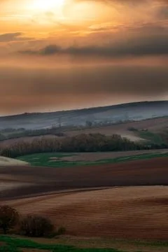 Beautiful view at sunset on the brown fields. Stock Photos