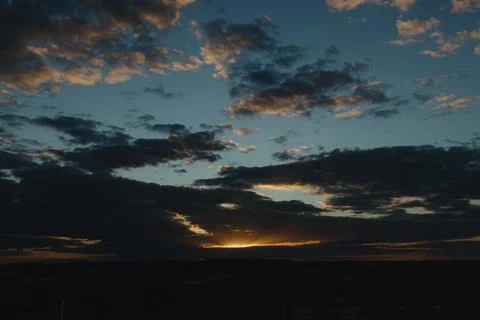 A beautiful view of a sunset with dramatic clouds in a blue sky. Stock Photos