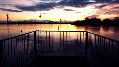 Beautiful view of sunset over a small lake with frozen lake water and wind Stock Footage 146244070