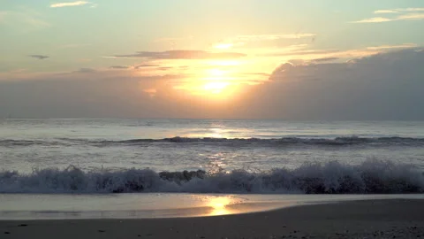 Beautiful view of sunset sky over the sea, ocean waves crashing on beach. Video stock 157528343