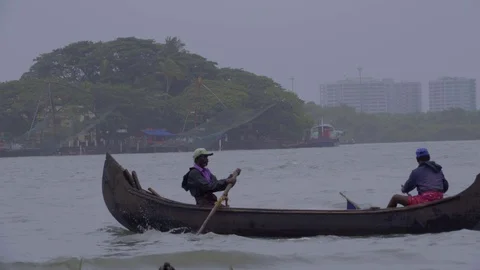Beautiful view of two men paddling canoe in Kochi river in India Stock Footage 106205809
