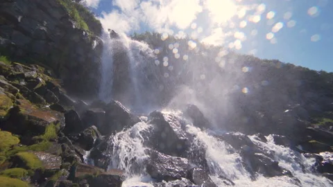 Beautiful view of the waterfall. High cliffs covered with green moss, the sun Stock Footage 96034206