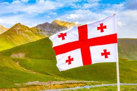 Beautiful view to waving flag of Georgia on the Georgian military road agains Stock Photos