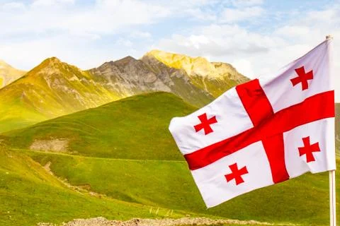 Beautiful view to waving flag of Georgia on the Georgian military road agains Stock Photos