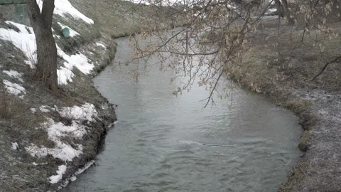Beautiful view of the winter stream, over which large snow falls. Bad weather Video stock 141868845