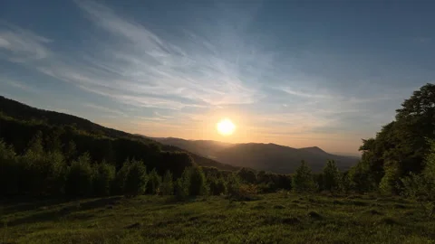 Beautiful warm sunset above forest and mountains in background Stock Footage 329568171