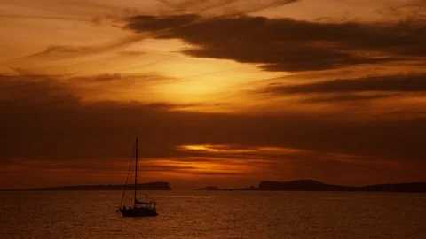 Beautiful warm sunset behind the clouds into Balearic sea with sail boat Stock-Footage 123087043
