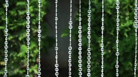 Beautiful water droplets cascade through glass strings outdoors Stock Footage 302102973