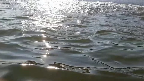 Beautiful water surface with sun glare. Sea wave in beams of the sun . Water Stock Footage 103414631