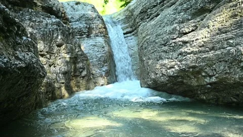 Beautiful waterfall in between rocks in the mountains Stock Footage 211492845
