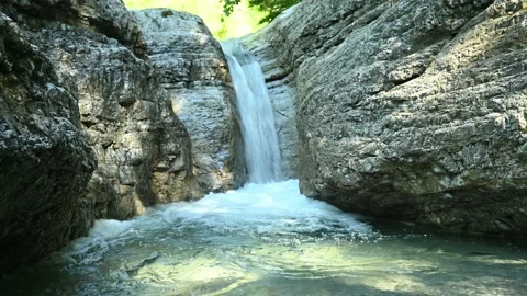 Beautiful waterfall in between rocks in the mountains Stock Footage 211493269