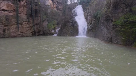Beautiful waterfall cascading into a mountain lake, scenic forest falls Stock Footage 330122232