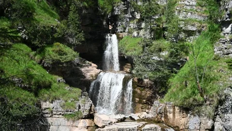 A beautiful waterfall cascading over rocks in the mountains Video stock 219385607